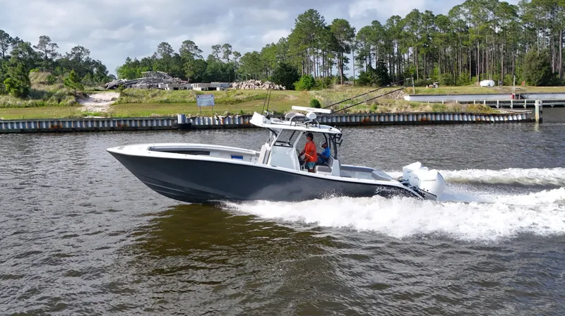 Slide: The Image of 2022 Yellowfin 34 boat cruising on a river with lush greenery in the background. - 11