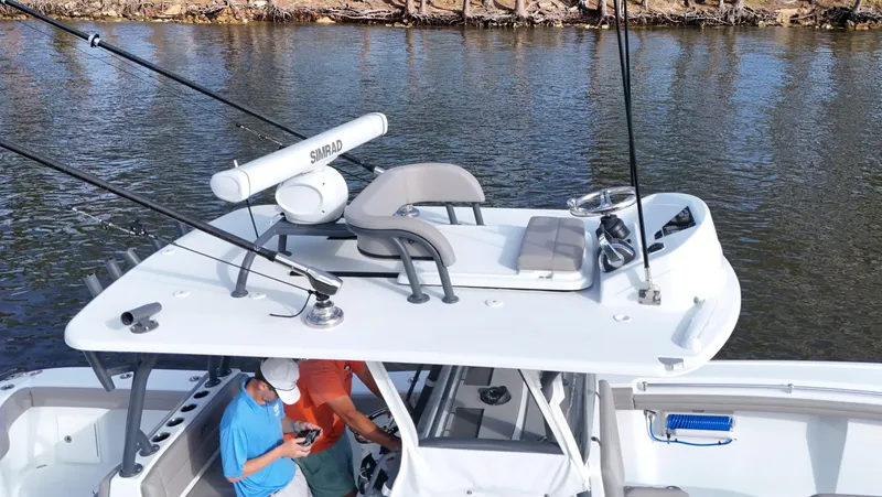Slide: The Image of 2022 Yellowfin 34 boat with radar and fishing rods on a calm river. - 23
