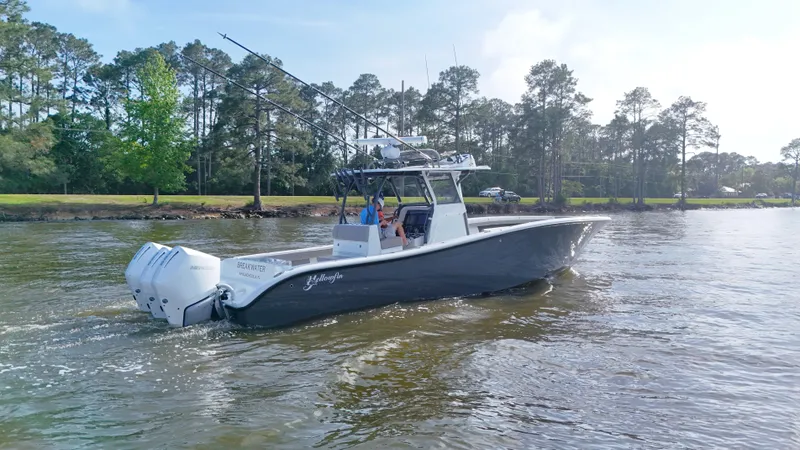 Slide: The Image of 2022 Yellowfin 34 boat cruising on a calm river with trees in the background. - 3