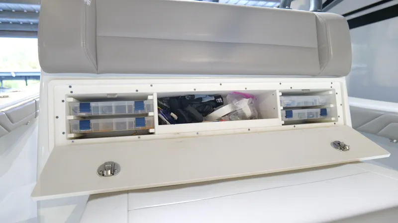 Slide: The Image of 2022 Yellowfin 34 boat storage compartment with organized tackle boxes and gear. - 36