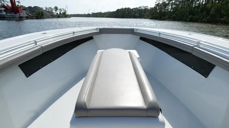 Slide: The Image of 2022 Yellowfin 34 boat interior with cushioned seating on a calm waterway. - 40