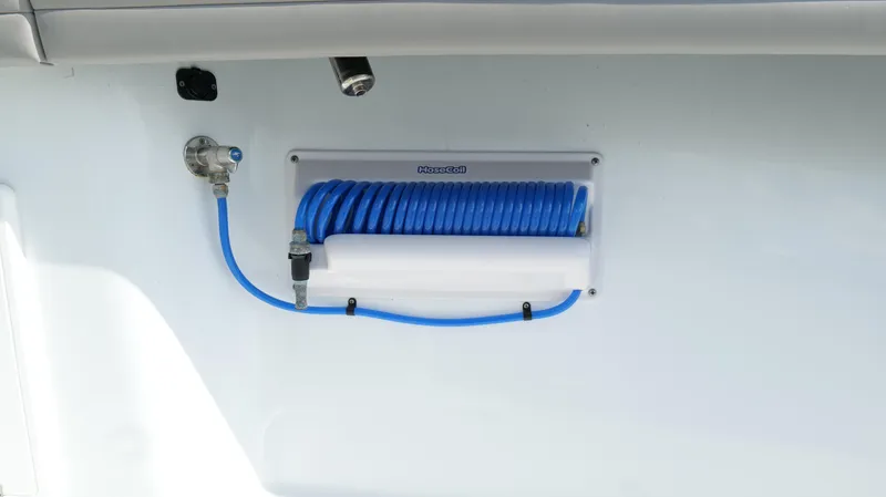 Slide: The Image of 2022 Yellowfin 34 boat with blue coiled hose and water connection. - 44