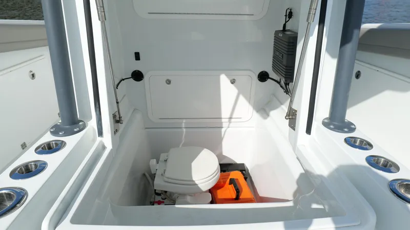 Slide: The Image of 2022 Yellowfin 34 boat interior with compact marine toilet and storage area. - 47