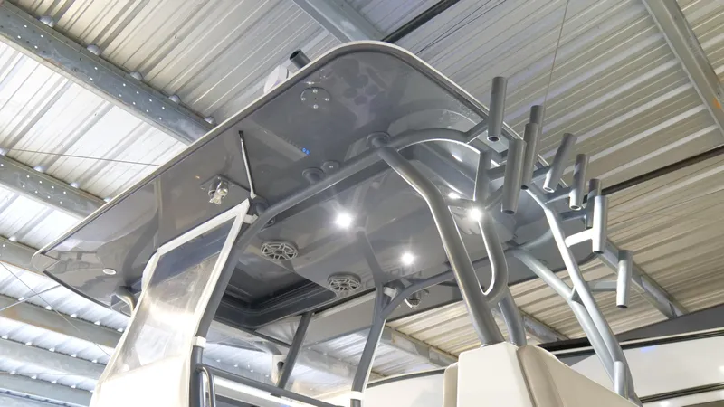 Slide: The Image of 2022 Yellowfin 34 boat with sleek T-top and rod holders in a metal-roofed storage. - 51