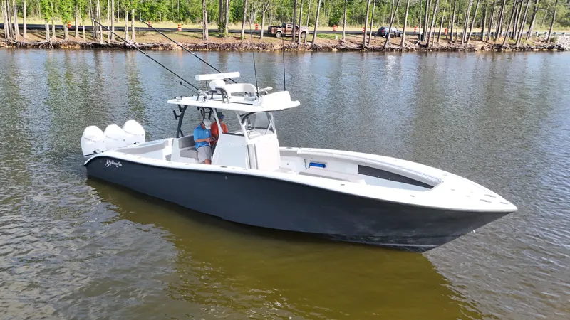 Slide: The Image of 2022 Yellowfin 34 boat on calm water, featuring triple outboard engines. - 6