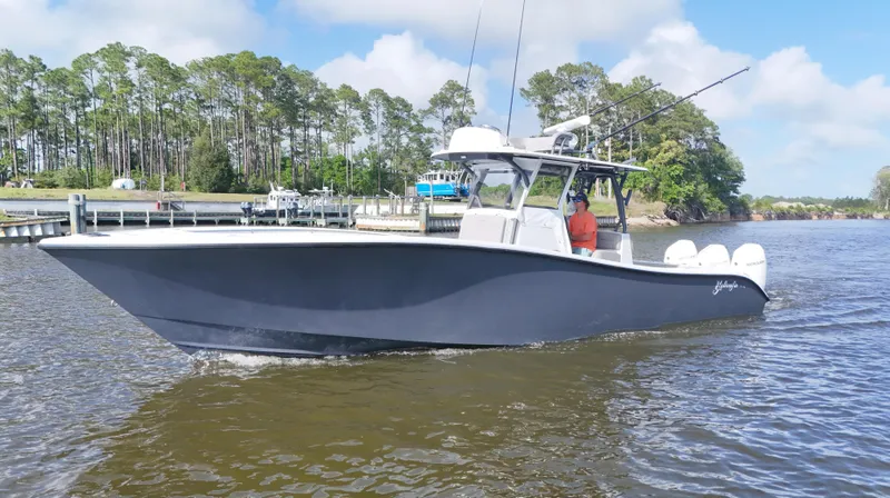 Slide: The Image of 2022 Yellowfin 34 boat cruising on a calm river with trees in the background. - 8