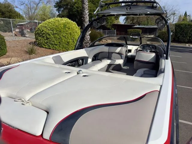 Slide: The Image of 2006 Malibu 247 LSV boat with spacious seating and sleek design in a sunny outdoor setting. - 11