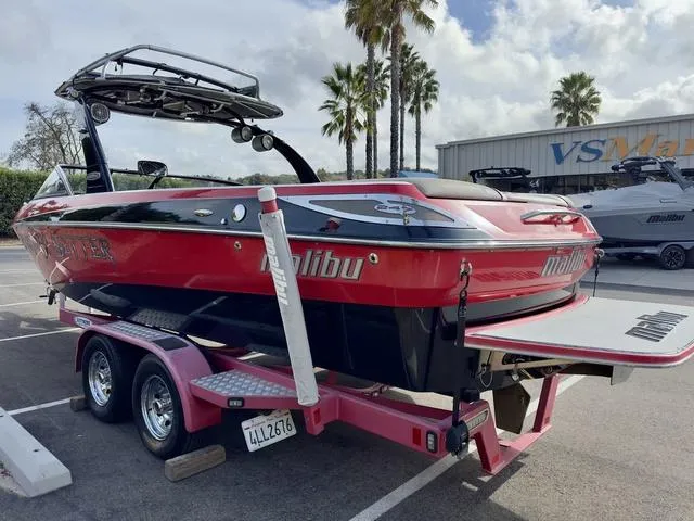Slide: The Image of 2006 Malibu 247 LSV boat on trailer, red and black, parked outdoors. - 6