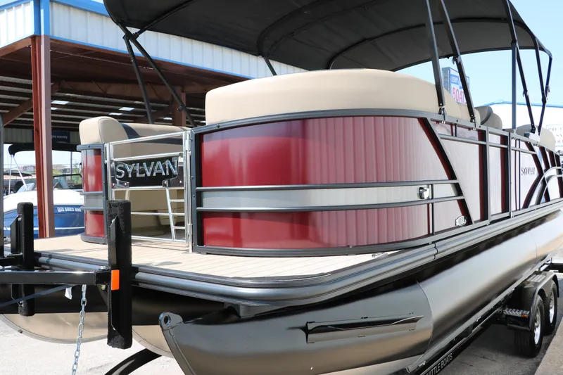 Slide: The Image of 2025 Sylvan L3 CLZ DH pontoon boat with red paneling and beige seating. - 7