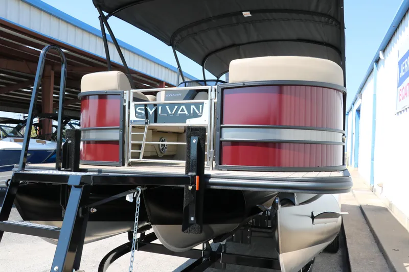 Slide: The Image of 2025 Sylvan L3 CLZ DH pontoon boat with red accents and canopy, docked in marina. - 9