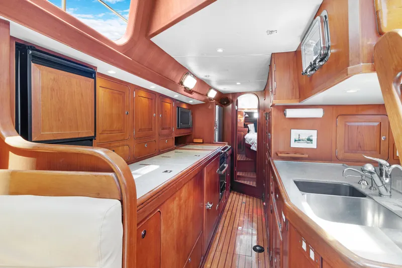 Slide: The Image of Luxurious 2009 Hylas 54 yacht interior with wooden cabinetry and modern kitchen amenities. - 38
