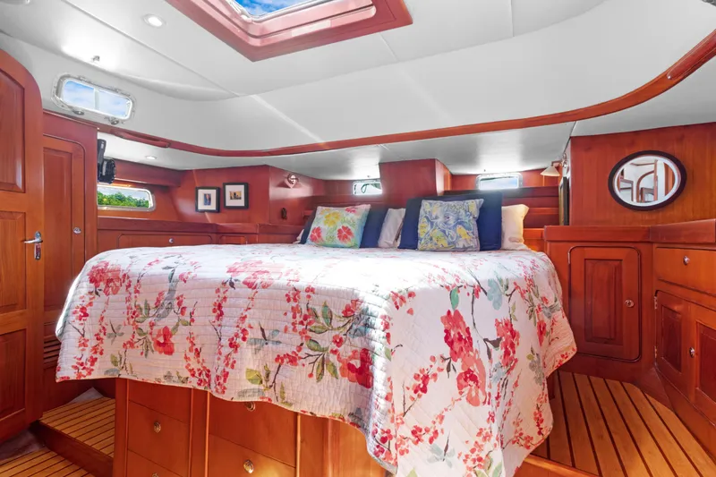 Slide: The Image of Luxurious 2009 Hylas 54 yacht cabin with floral bedding and wooden interior. - 45