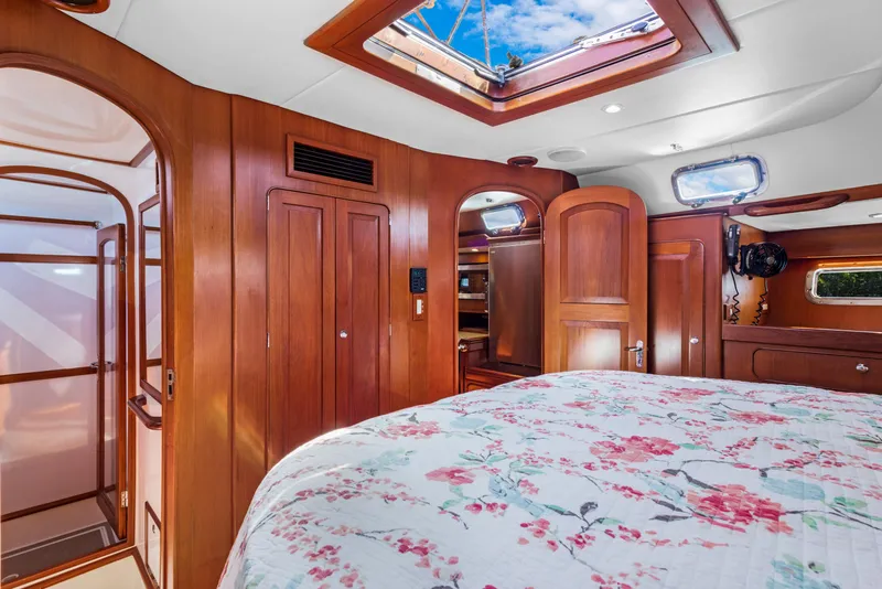 Slide: The Image of Luxurious 2009 Hylas 54 yacht interior with wood paneling and floral bedding. - 46