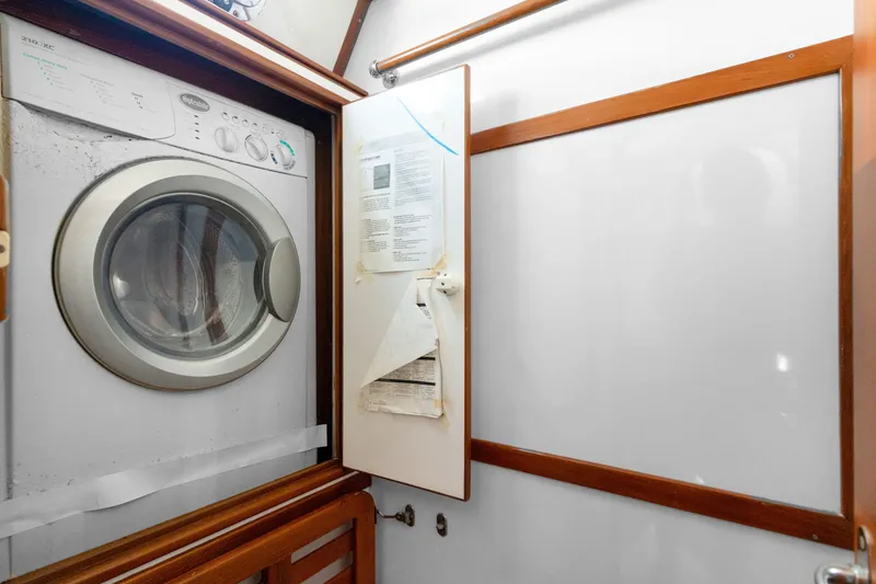 Slide: The Image of Washer and dryer unit inside a 2009 Hylas 54 yacht's wooden cabinet. - 49