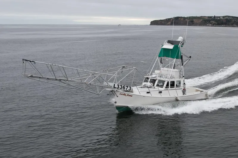 Slide: The Image of A 2004 Beal 34 boat cruising on open water with a large metal structure. - 0