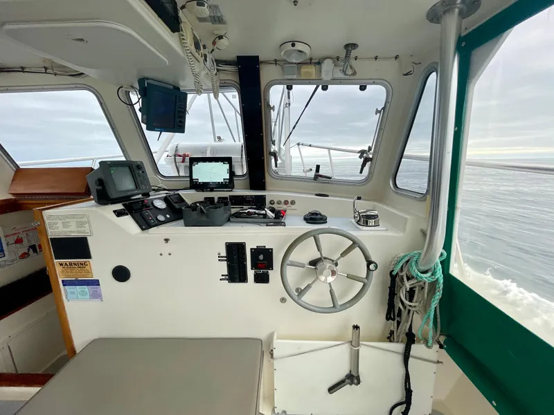 Slide: The Image of Interior of a 2004 Beal 34 boat cockpit with navigation equipment and steering wheel. - 11
