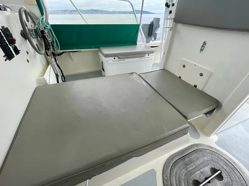 Slide: The Image of Interior of a 2004 Beal 34 boat with cushioned seating and steering wheel. - 25