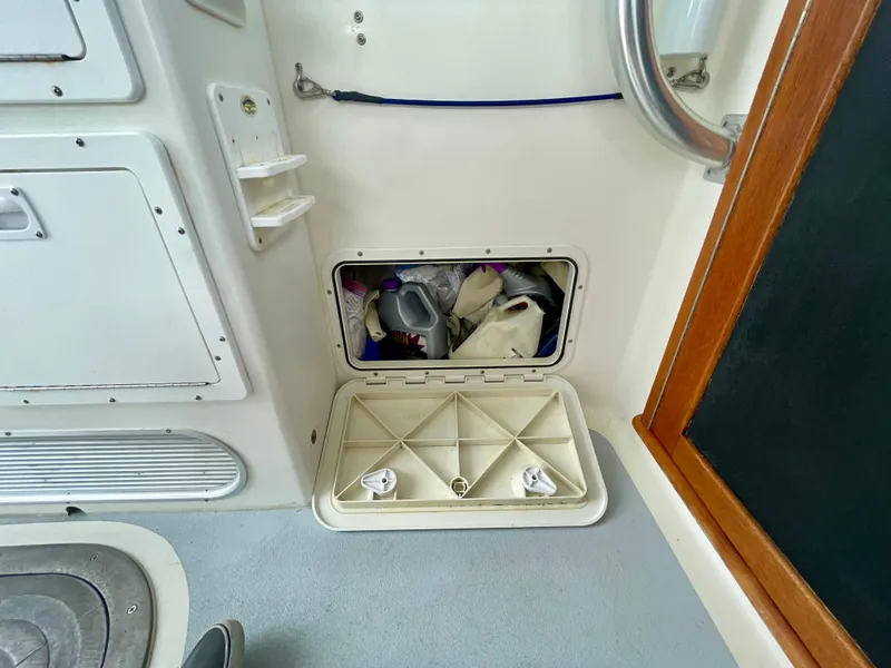 Slide: The Image of Storage compartment on a 2004 Beal 34 boat, containing various items. - 26