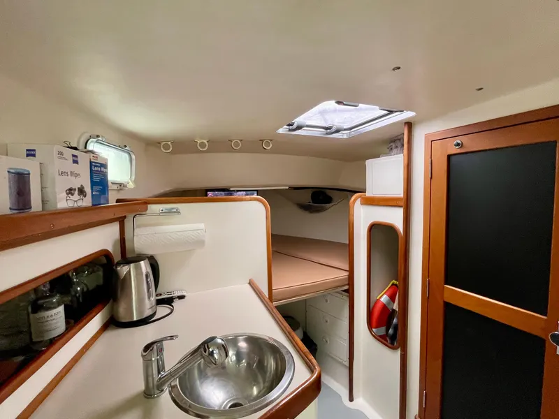 Slide: The Image of Compact boat interior with kitchenette, sink, and cozy sleeping area in a 2004 Beal 34 model. - 33