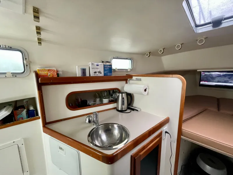 Slide: The Image of Compact boat kitchen with sink, kettle, and storage in a 2004 Beal 34 model. - 35