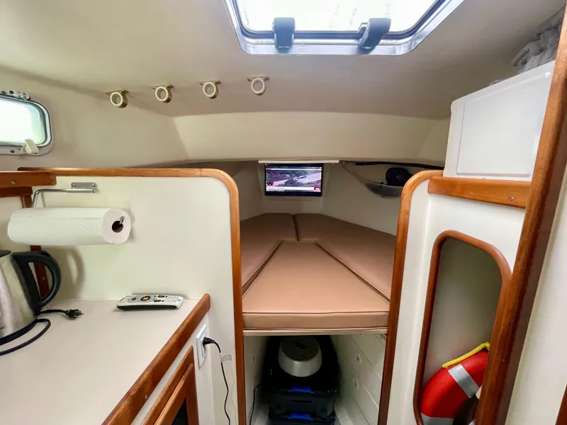 Slide: The Image of Interior of a 2004 Beal 34 boat cabin with bed, window, and kitchenette. - 36