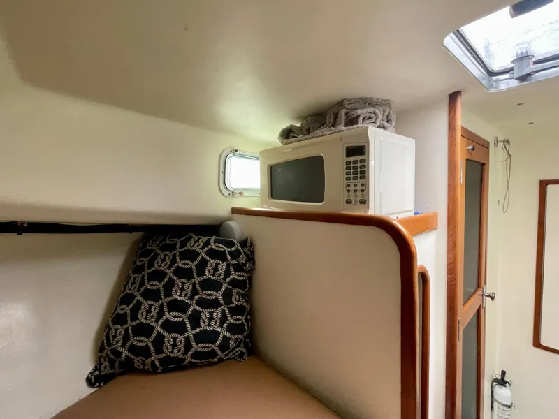 Slide: The Image of Cozy cabin interior of 2004 Beal 34 boat with microwave and patterned pillow. - 39