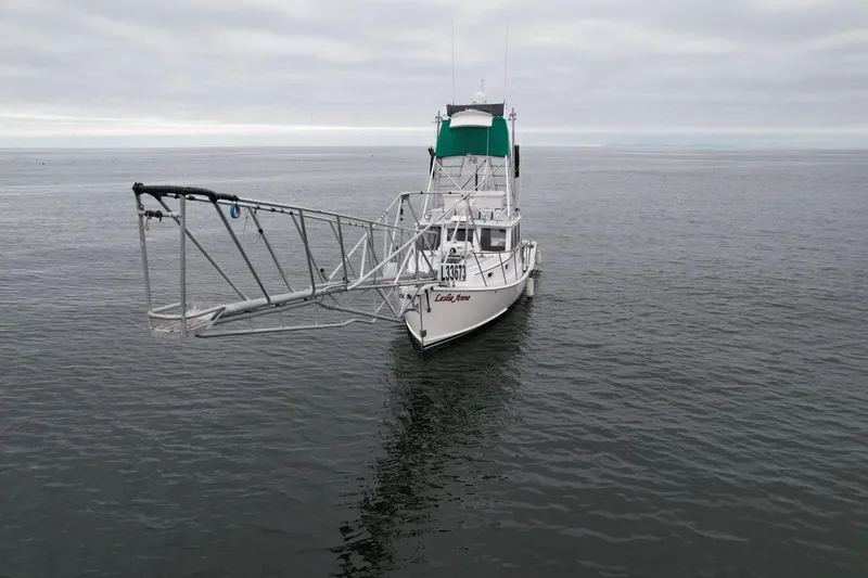 Slide: The Image of A 2004 Beal 34 boat with a large metal structure on open water under cloudy skies. - 4