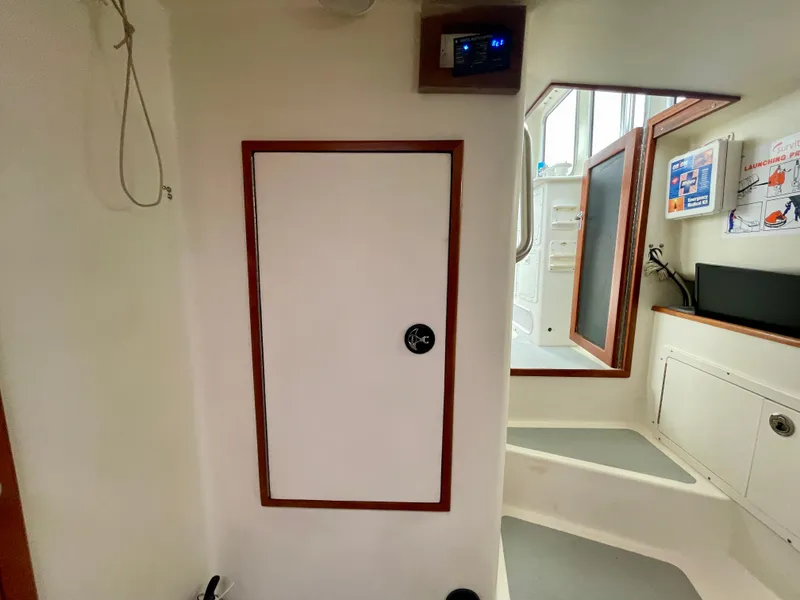 Slide: The Image of Interior of a 2004 Beal 34 boat, featuring a white door and steps. - 43