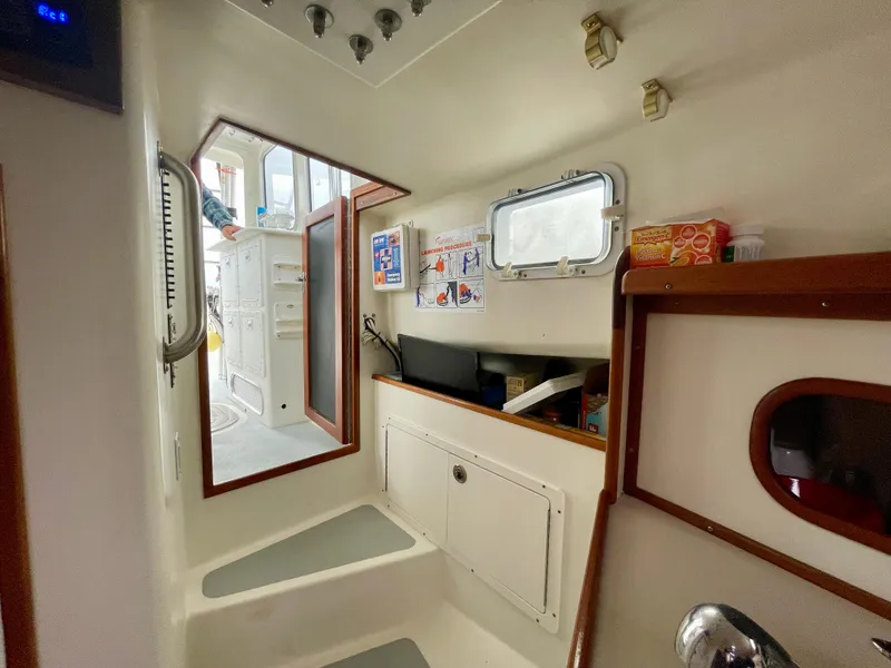 Slide: The Image of Interior of a 2004 Beal 34 boat, featuring storage, window, and nautical decor. - 47
