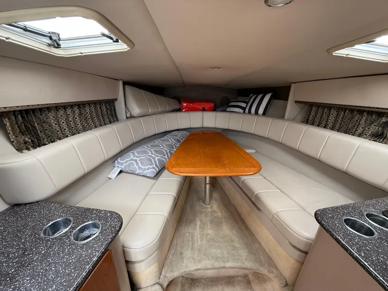 Slide: The Image of Interior of 2004 Formula 330 Sun Sport boat with beige seating and wooden table. - 10