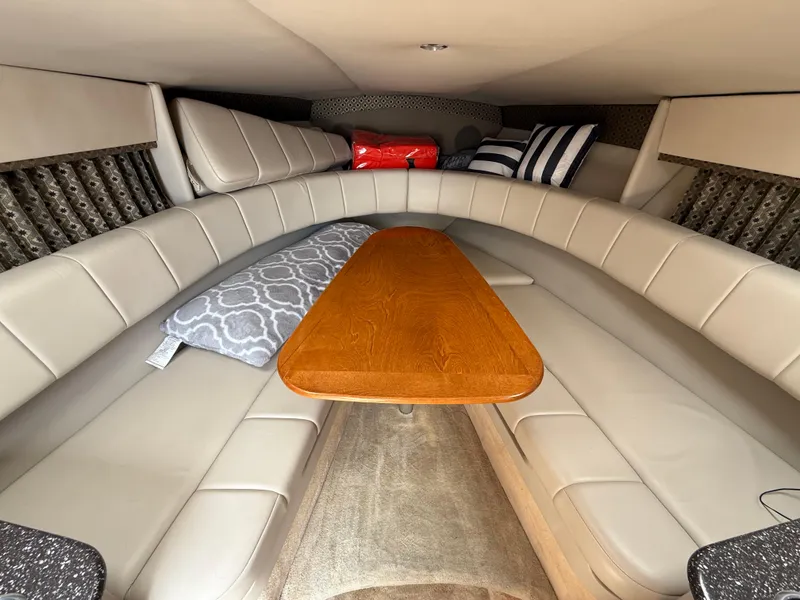 Slide: The Image of 2004 Formula 330 Sun Sport cabin with beige seating and wooden table. - 13