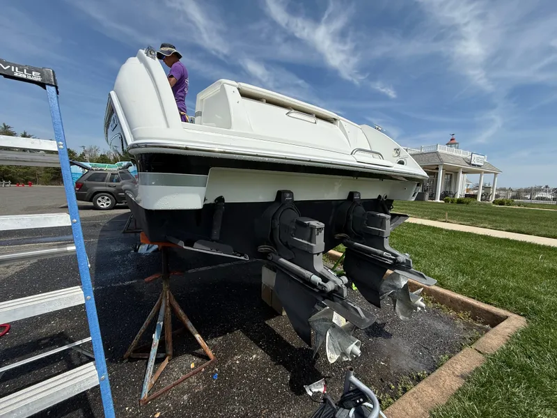 Slide: The Image of 2004 Formula 330 Sun Sport boat on stands, undergoing maintenance, with a clear sky backdrop. - 19