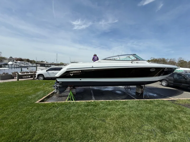 Slide: The Image of 2004 Formula 330 Sun Sport boat on display in a marina setting. - 2