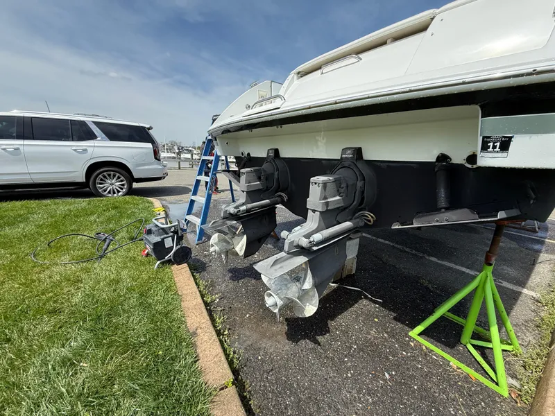 Slide: The Image of 2004 Formula 330 Sun Sport boat on stands, with visible propellers and parked SUV nearby. - 20