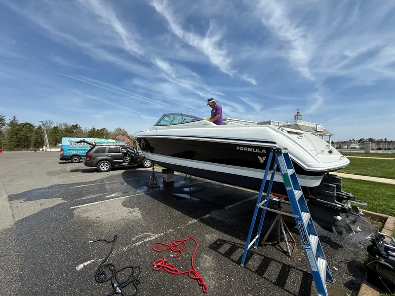 Slide: The Image of 2004 Formula 330 Sun Sport boat on trailer, parked with maintenance equipment nearby. - 21