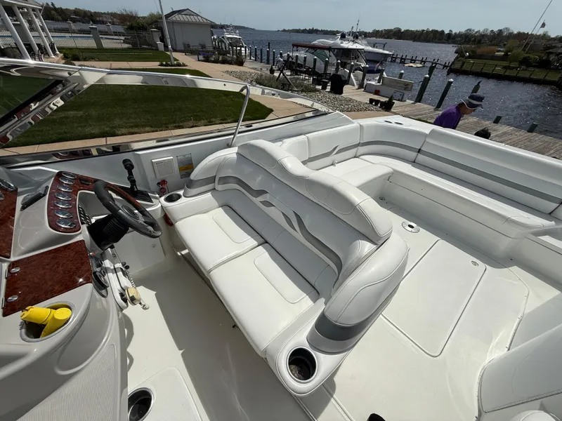 Slide: The Image of 2004 Formula 330 Sun Sport boat interior with white seating and steering wheel, docked by the water. - 8