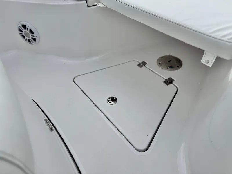 Slide: The Image of 2022 Sportsman Heritage 241 Center Console boat interior with storage compartment and speaker. - 11