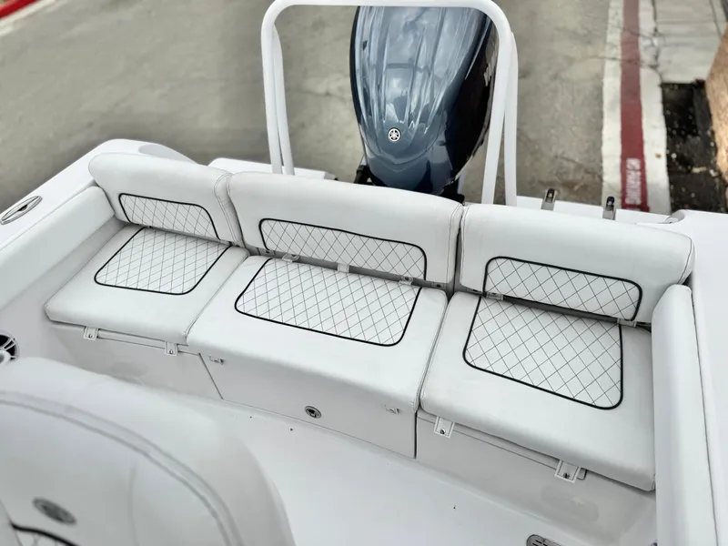 Slide: The Image of 2022 Sportsman Heritage 241 Center Console boat with cushioned seating and outboard motor. - 17