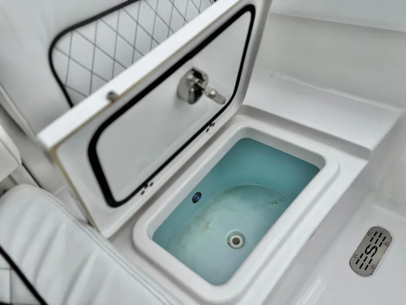 Slide: The Image of 2022 Sportsman Heritage 241 Center Console livewell with open lid and cushioned seating. - 18