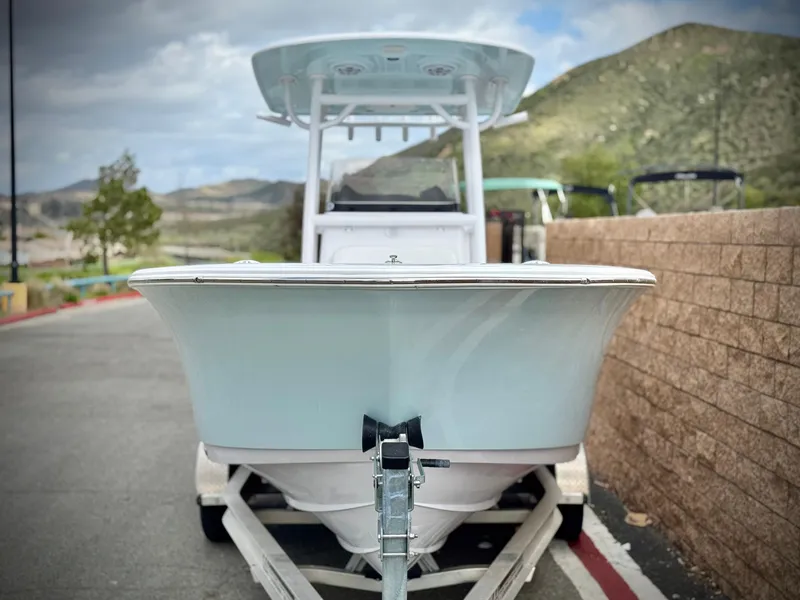Slide: The Image of 2022 Sportsman Heritage 241 Center Console boat on trailer, parked near a scenic mountain backdrop. - 2