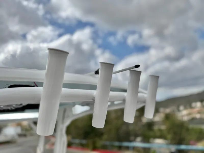 Slide: The Image of Rod holders on a 2022 Sportsman Heritage 241 Center Console boat under cloudy sky. - 21