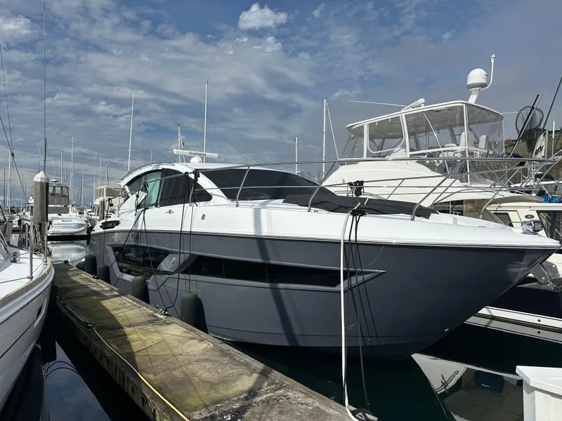 Slide: The Image of 2023 Cruisers Yachts 46 Cantius docked at marina under blue sky. - 1
