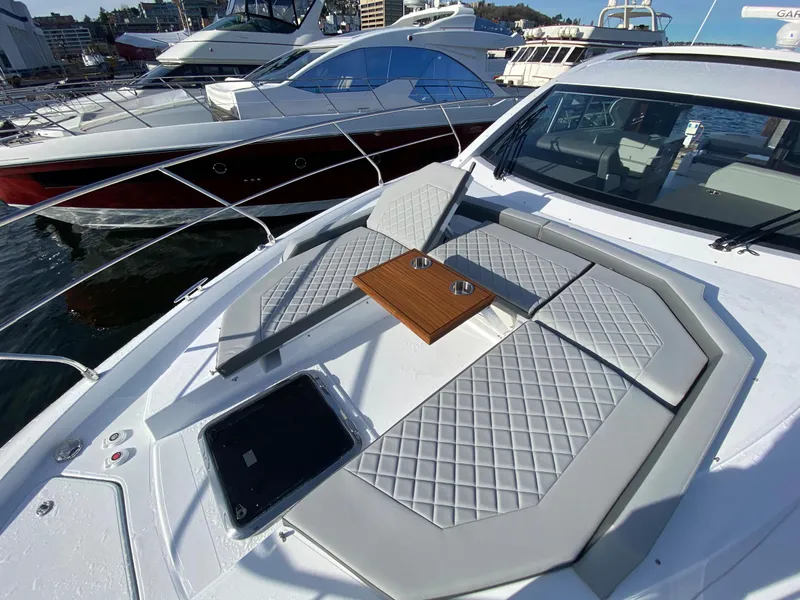 Slide: The Image of 2023 Cruisers Yachts 46 Cantius with luxurious deck seating and table, docked at marina. - 14