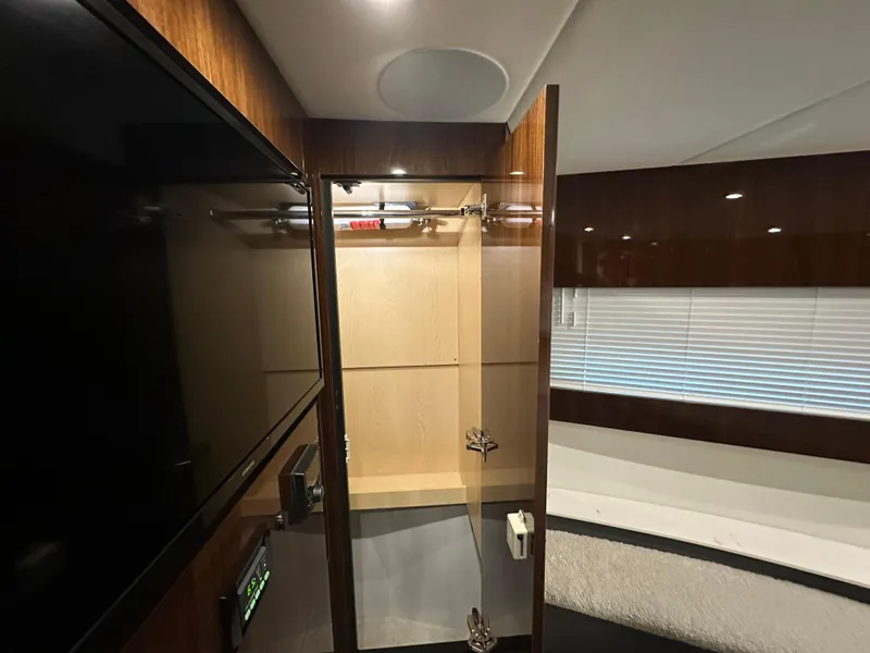 Slide: The Image of Interior of 2023 Cruisers Yachts 46 Cantius, featuring a sleek wooden closet and modern design. - 25