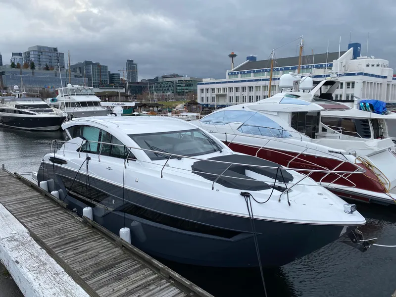 Slide: The Image of 2023 Cruisers Yachts 46 Cantius docked in a marina with cityscape background. - 3