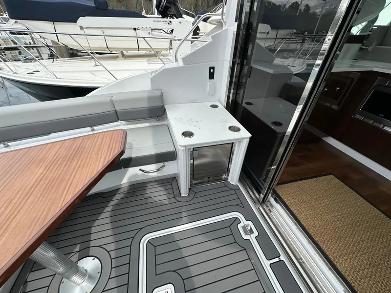 Slide: The Image of 2023 Cruisers Yachts 46 Cantius deck with seating, table, and storage. - 38