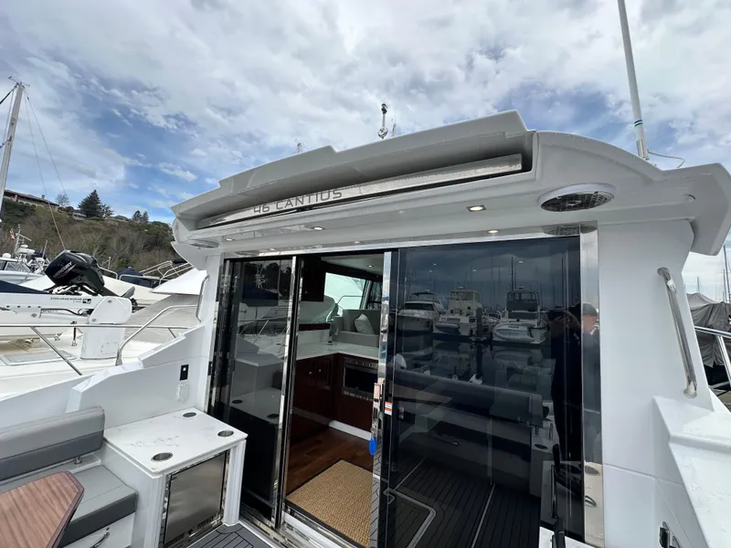 Slide: The Image of 2023 Cruisers Yachts 46 Cantius with open sliding doors, docked at a marina. - 39