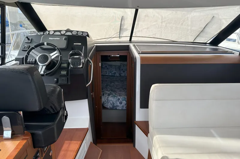 Slide: The Image of Interior of 2016 Jeanneau NC 11 boat, featuring helm, seating, and cabin entrance. - 10