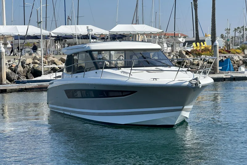 Slide: The Image of 2016 Jeanneau NC 11 boat docked in a marina, calm waters, sunny day. - 2