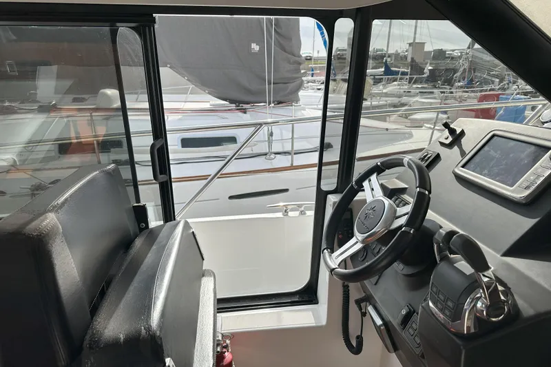 Slide: The Image of Interior view of 2016 Jeanneau NC 11 boat cockpit with steering wheel and navigation equipment. - 5